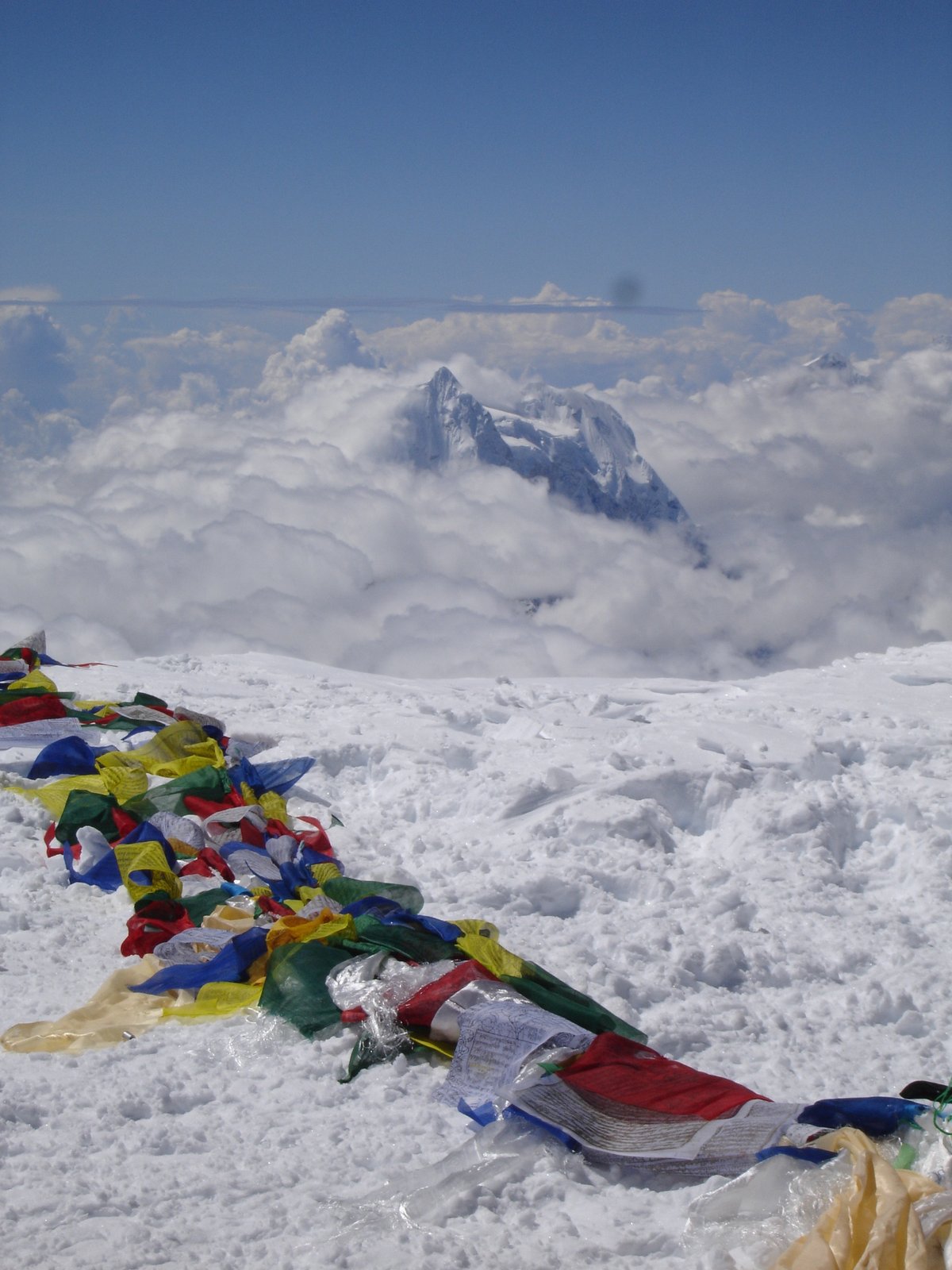 Les drapeaux de prière du sommet, au-dessus d'une mer de nuages.