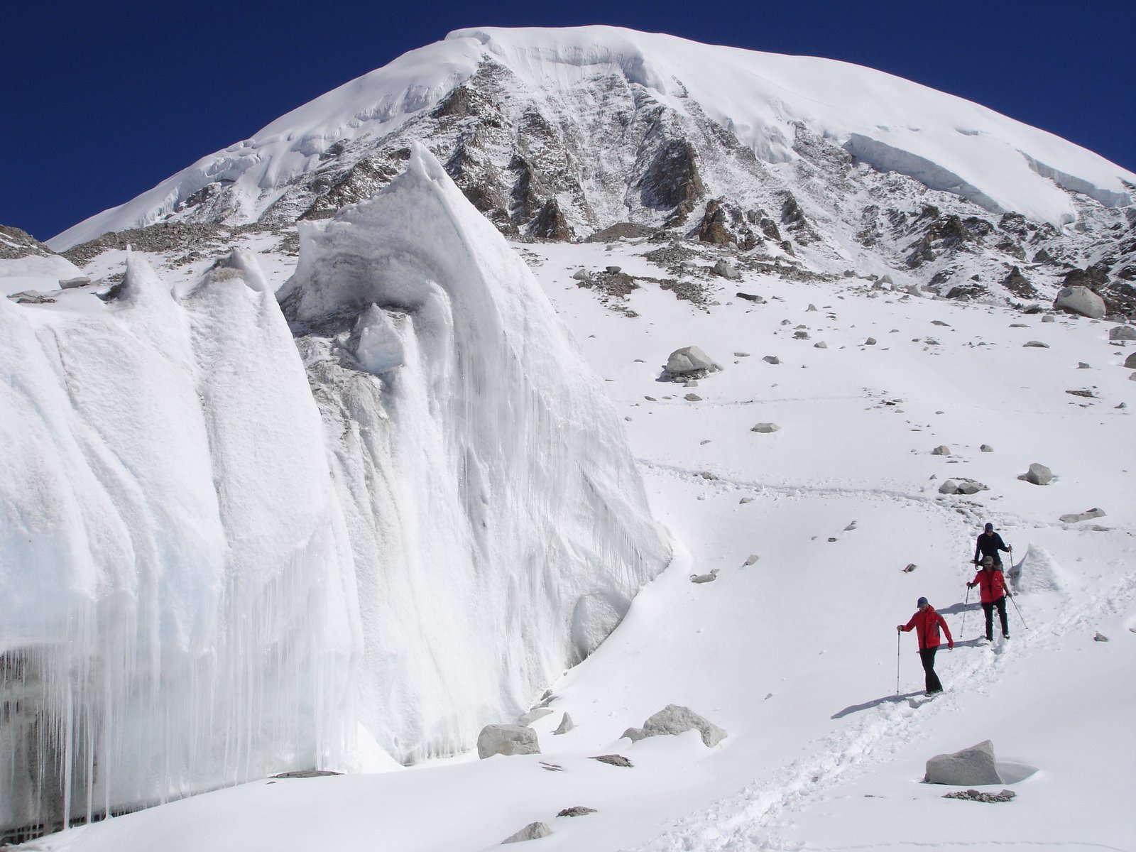 Sous la barre de séracs du Cho Oyu, grimpeurs minuscules face à la paroi